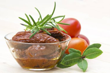 Kurutulmuş domates, taze domates ve otlar.