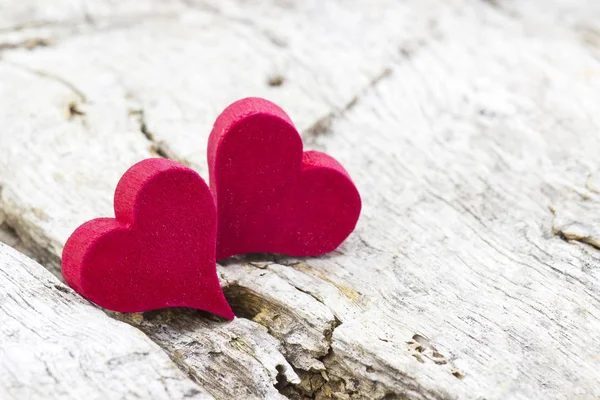 Dos corazones rojos sobre fondo de madera — Foto de Stock