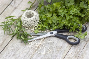 Ahşap arka plan üzerinde makas ve dize ile taze hasat otlar