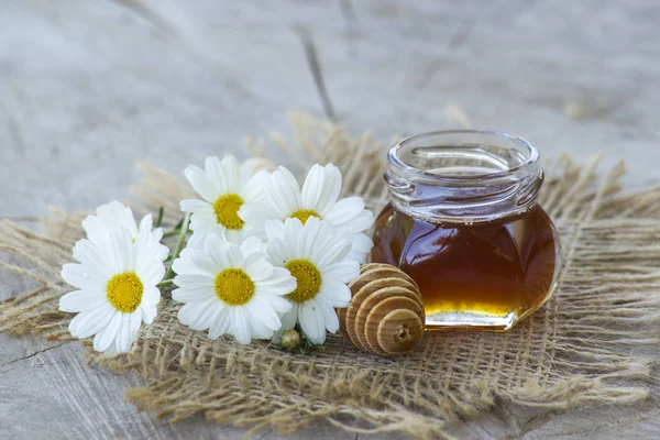 Miel y flores sobre fondo de madera —  Fotos de Stock