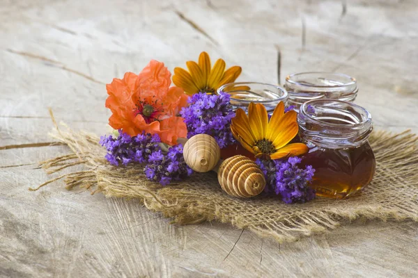 Miel y flores sobre fondo de madera —  Fotos de Stock