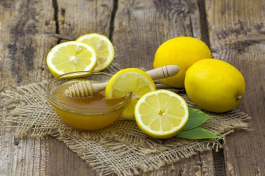 Bal ve ahşap zemin üzerine taze limon ile kase