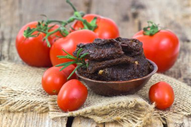 Tahta zemin üzerinde taze ve kuru domatesler.