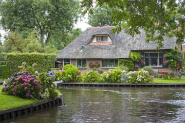 GIETHOORN, NETHERLANDS - evlerin ve bahçelerin tipik Hollanda ilçesi