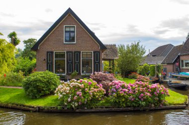 GIETHOORN, NETHERLANDS - evlerin ve bahçelerin tipik Hollanda ilçesi