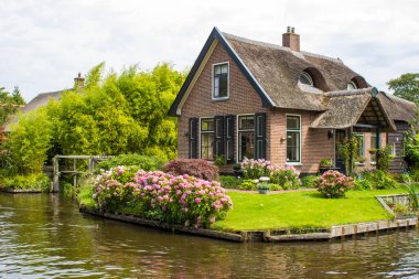 GIETHOORN, NETHERLANDS - evlerin ve bahçelerin tipik Hollanda ilçesi