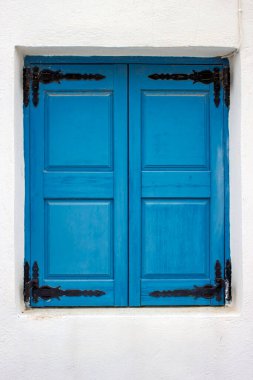 Kapalı panjurlu pencere geleneksel mavi renge boyanmış i Akrotiri, Santorini, Yunanistan