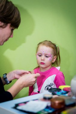 Makyaj sanatçısı Cadılar Bayramı partisine kız makyaj uygulamak.