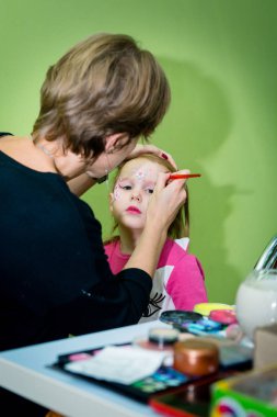 Makyaj sanatçısı Cadılar Bayramı partisine kız makyaj uygulamak.