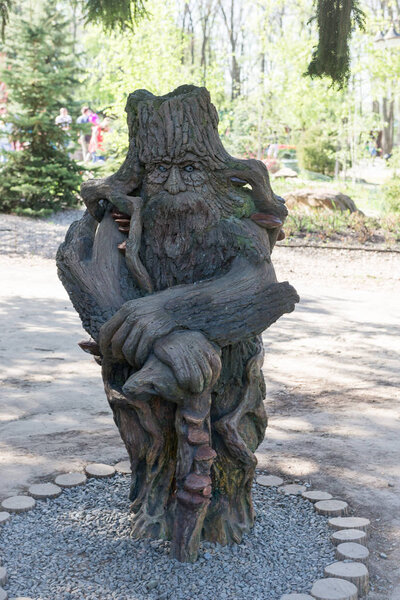 Sculpture of an evil monster made of wood close-up in the park.