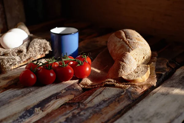 Сільський сніданок з хлібом, помідорами та яйцем на дерев'яному фоні — стокове фото