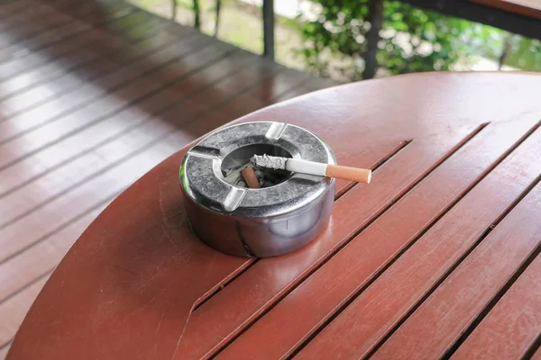 タバコ灰皿配置テーブル ウッドの背景で — ストック写真