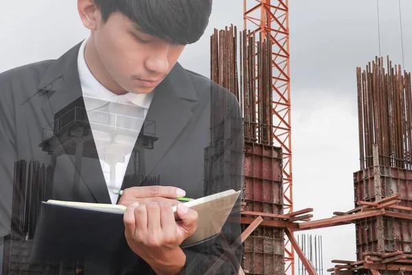 Not defteri El inşaat site işyeri kavramı içinde belgelerin imzalanması ile işadamı çift pozlama.