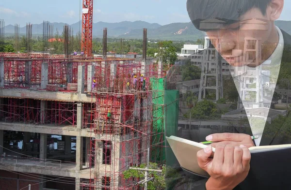 Not defteri El inşaat site işyeri kavramı içinde belgelerin imzalanması ile işadamı çift pozlama.