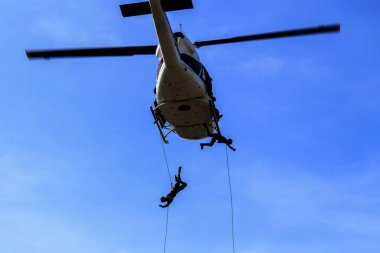 Asker helikopter mavi gökyüzünde ip atlama siluet