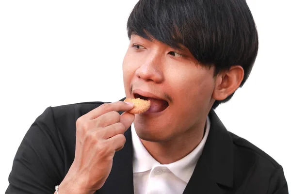 年轻男子英俊吃饼干小块白色背景 — 图库照片