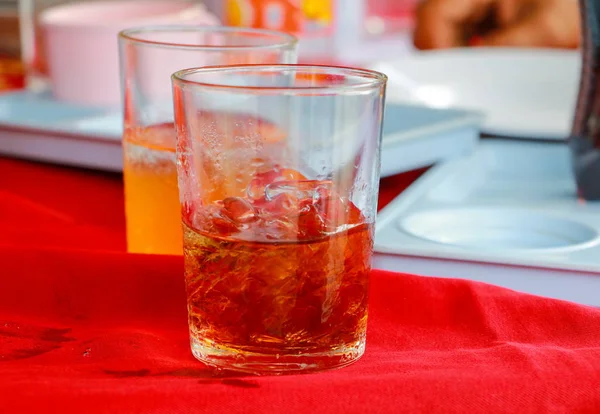 Cam alkolsüz içecek olan bir tablo kırmızı kumaş üzerine