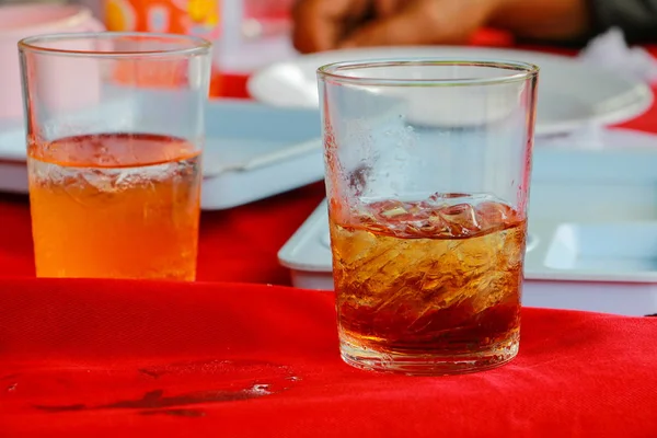 Cam alkolsüz içecek olan bir tablo kırmızı kumaş üzerine