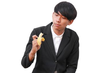 Yakışıklı delikanlı beyaz arka plan üzerinde bir muz yemek