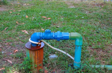 su vanası sıhhi tesisat çelik katıldı ve çim üzerinde mavi boyalı ile Değiştir Onar borular vardır