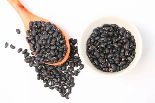 yukarıdan tahta kaşıkla ve Kupası beyaz arka planda siyah fasulye görüntülemek