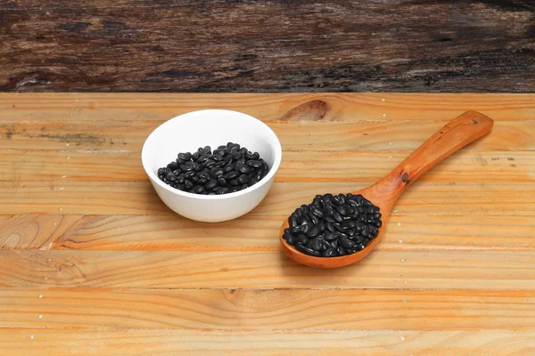 tahta kaşıkla ve Kupası ahşap zemin zemin üzerine siyah fasulye