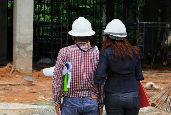 mimar-mühendis işadamı ve kadın sitesi yapı inşaat kask takmak, arkadan görünüm