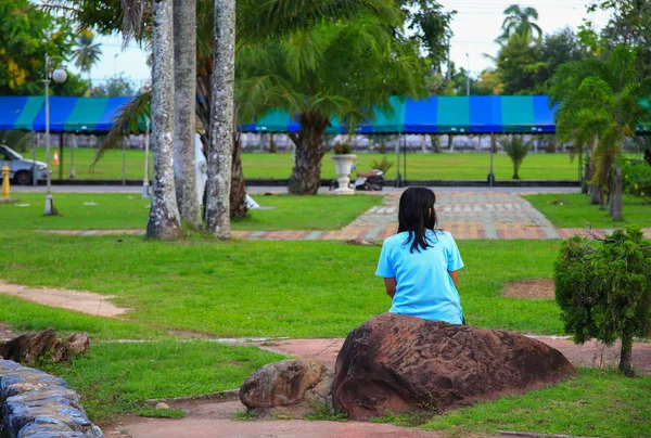 Γυναίκα Που Κάθεται Στην Πέτρα Ένα Δημόσιο Πάρκο — Φωτογραφία Αρχείου
