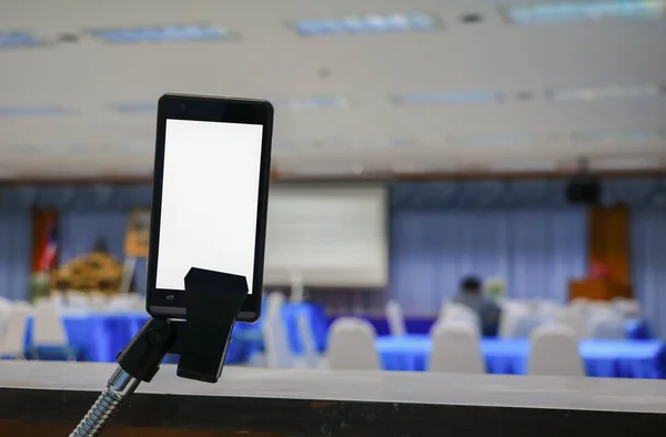 smartphone take on white screen of the meeting room business select focus with shallow depth of field.