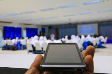 seminer konferans sınıfta tutan smartphone el: seçin odak alan sığ derinliği ile.