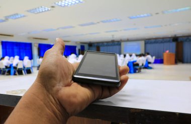 seminer konferans sınıfta tutan smartphone el: seçin odak alan sığ derinliği ile.