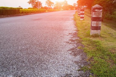 siyah ve beyaz boyalı kilometre taşı. gün batımı hafif sesi seçin odak alan sığ derinliği ile yol aralığı kenarı.