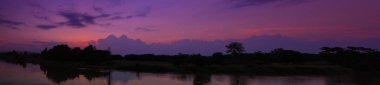 Panorama günbatımı gökyüzünde güzel renkli manzara siluet ağaç orman ve nehir twilight saat yansıtacak