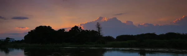 パノラマの夕日空に美しいカラフルな風景シルエット ツリー森と川が黄昏時を反映して — ストック写真