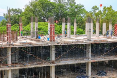 İnşaat işçi ekibi yüksek zemin ticari bina sitesi işyerinde çalışıyor