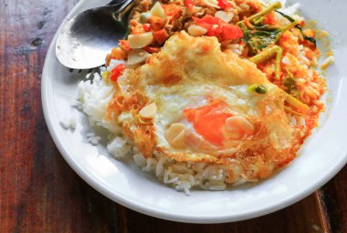 Pirinç kızarmış yumurta ve köri baharatlı Tayland gıda ile ahşap masa üzerinde tavuk Fesleğenli tepesinde kapatın