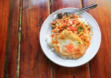 Pirinç kızarmış yumurta ve köri baharatlı Tayland gıda ile ahşap masa üzerinde tavuk Fesleğenli tepesinde kapatın