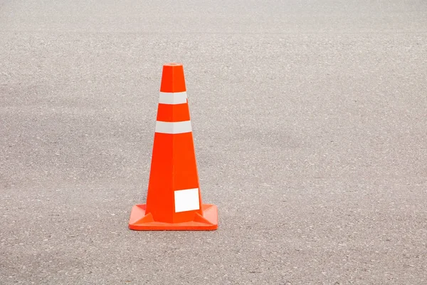 Traffic cone old orange and swath white stripes on the road with copy space