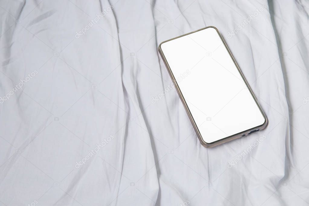 cell phone on white bed in Interior train with copy space add text