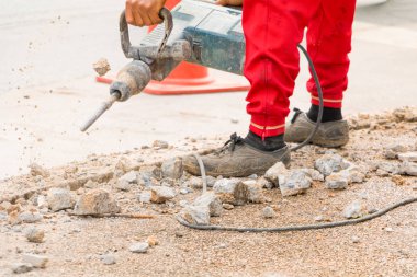 İnşaat sondaj onarım işçisi yol yüzeyinde 