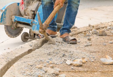 İnşaat sondaj onarım işçisi yol yüzeyinde 