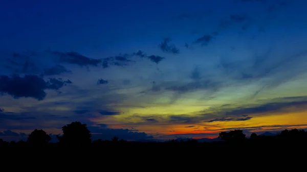 Pôr do sol bonito no céu cor e árvore silhueta — Fotografia de Stock