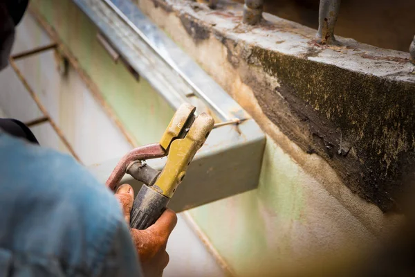 Agarre de mano de soldador de edad trabaja reparación de soldadura de acero en el techo — Foto de Stock