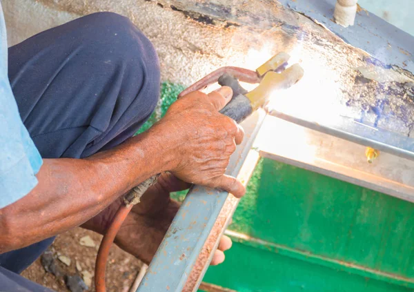 Agarre de mano de soldador de edad trabaja reparación de soldadura de acero en el techo — Foto de Stock