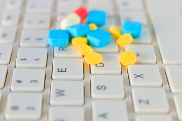 Fechar pílulas e cápsula no teclado do computador branco — Fotografia de Stock