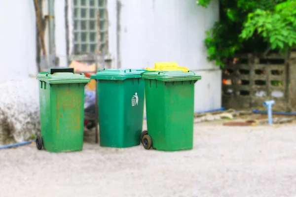 Trashcan πράσινο κάδο απορριμμάτων σκουπιδοτενεκέδες που βρίσκονταν έξω από το τείχος παρασκήνιο — Φωτογραφία Αρχείου