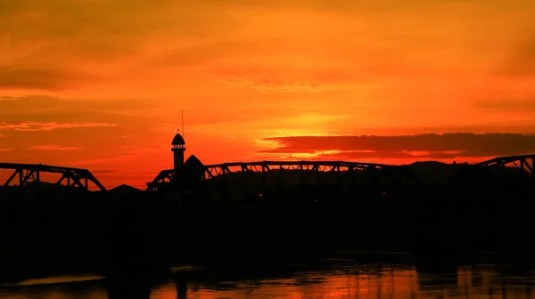 Silhueta ponte ferroviária e reflexo no rio antes do nascer do sol — Fotografia de Stock