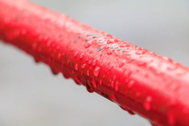 eski metal çelik boru kırmızı zemin üzerine su damlaları