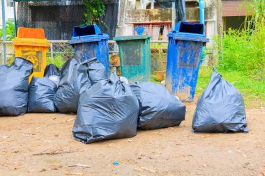 kazık siyah çöp torbası plastik ve dört çöp kovası kirli yol kenarı 