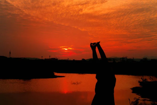 Silueta de mujer ejercita ribera al atardecer Amarillo en el cielo — Foto de Stock